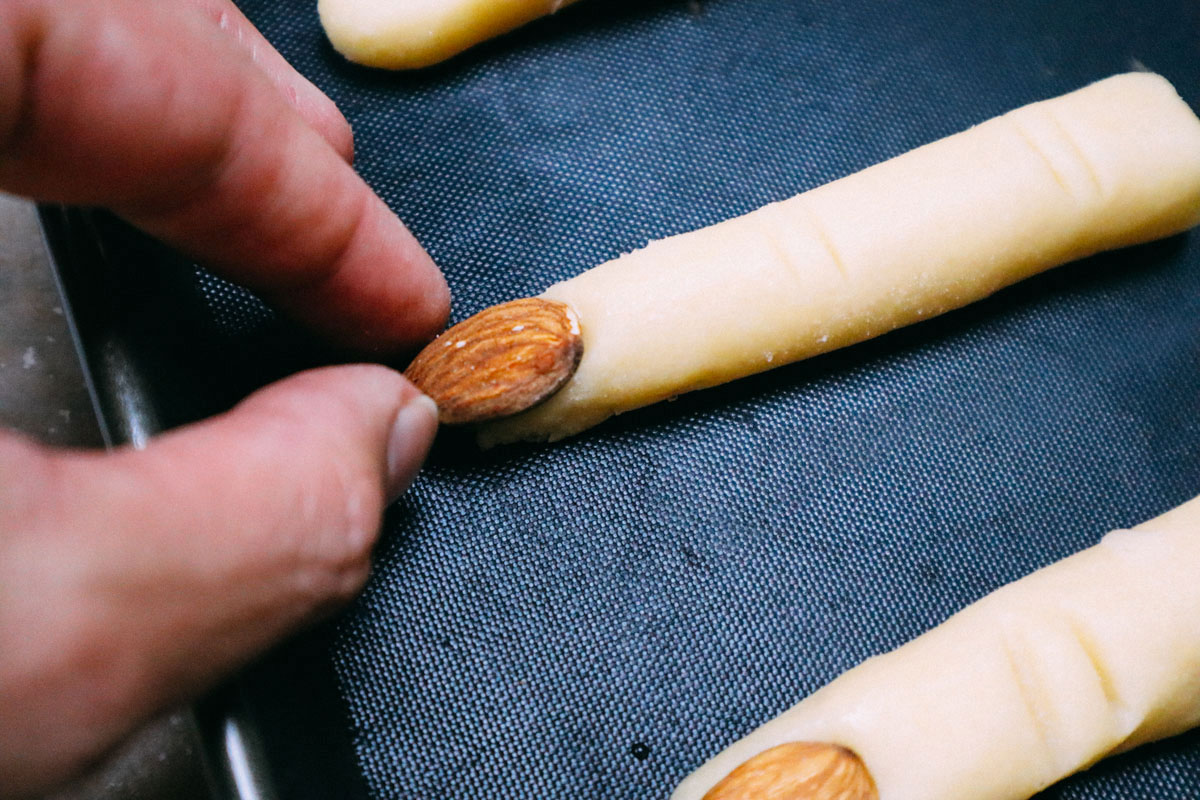 Aggiungere le unghia alle dita della strega prima di mettere in forno.
