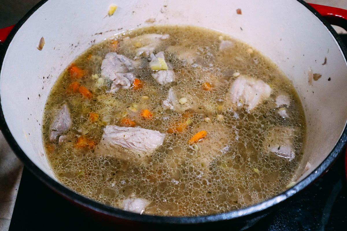 Cottura delle lenticchie in brodo. Il brodo copre tutte le verdure e i legumi.