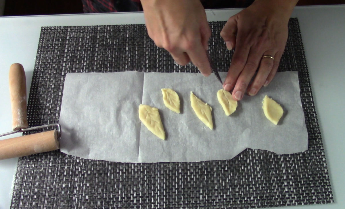 Ritaglio delle foglie in pasta brisé, realizzate con un coltellino dopo aver steso la pasta.