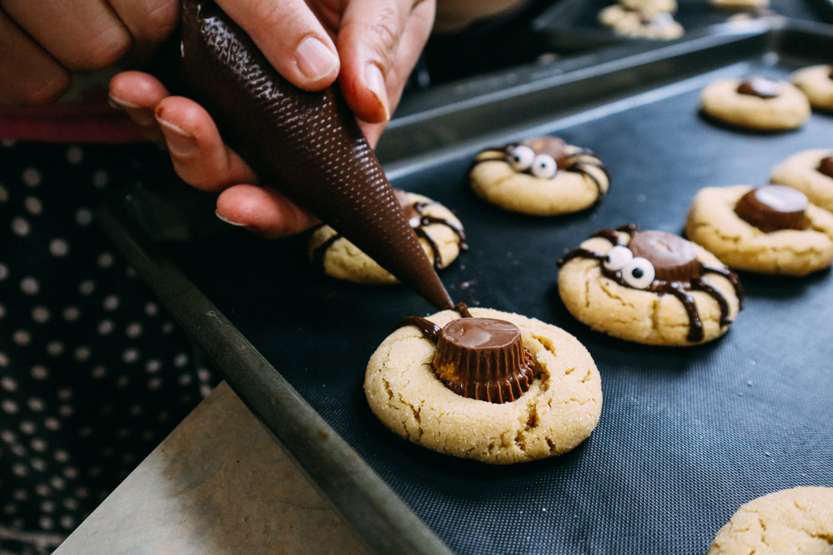 Ragni di Halloween, fase finale della realizzazione delle gambe di cioccolato e attacco degli occhi di zucchero.