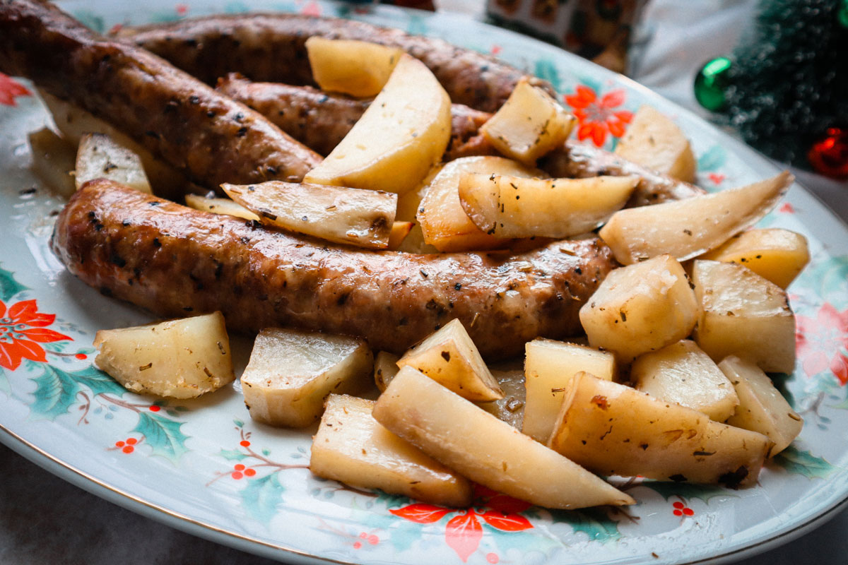 Salsiccia e patate al forno, servite su piatto da portata.