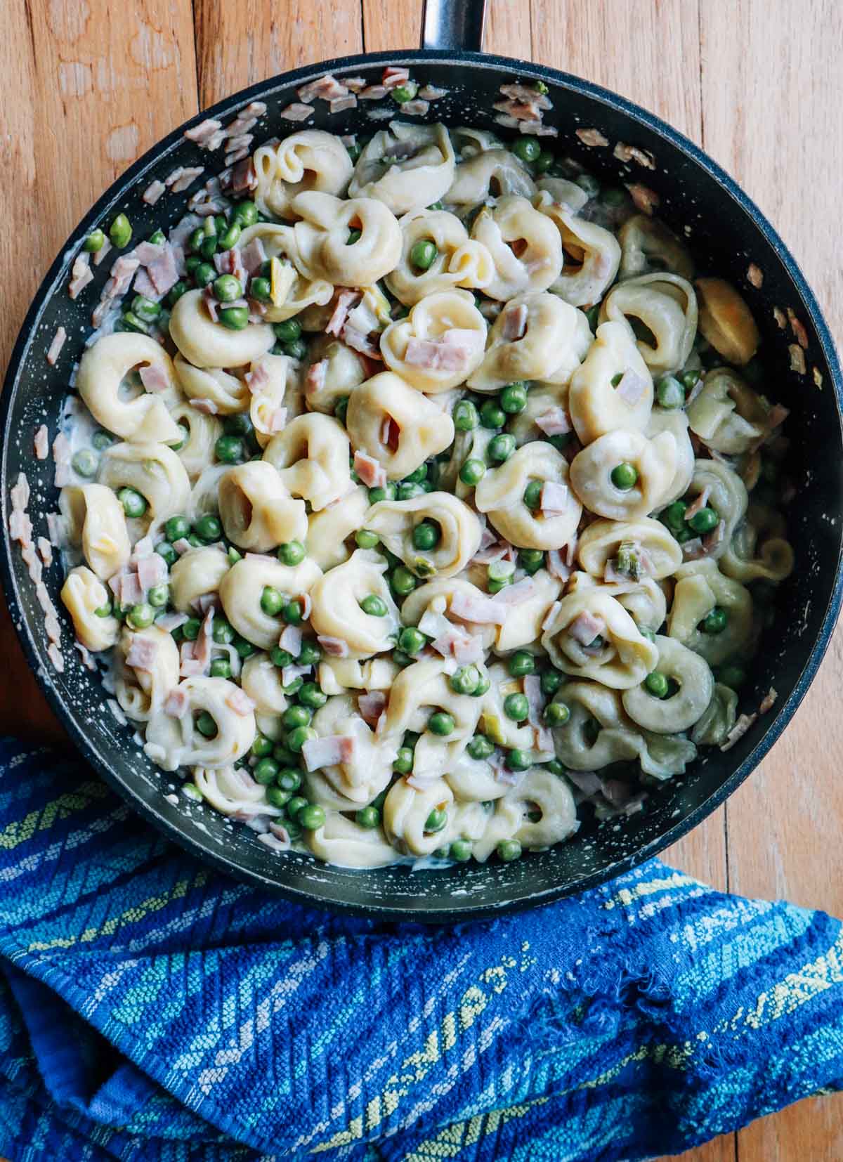 Primo piano del tegame con tortellini con panna e prosciutto.