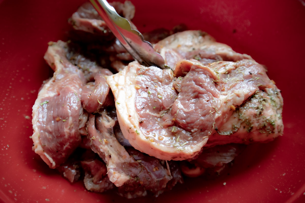 Carni di abbacchio marinate e pronte a essere messe in frigorifero a riposo.